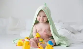 Roztomilé miminko batole chlapeček hraje s gumovými kachnami