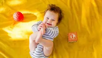 dieťa sa hrá s blokmi na posteli