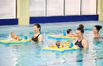 Záber na matky, ktoré si užívajú svoje deti na hodine plávania