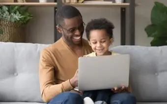 papa et fils jouent à un jeu informatique