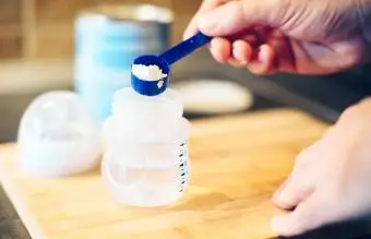 Pai fazendo leite em pó para bebês