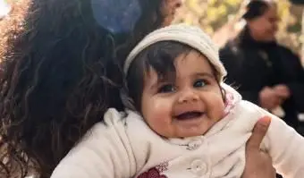 Bambino felice portato in braccio dalla madre