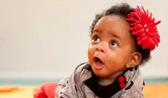 תינוקת עם פרח אדום