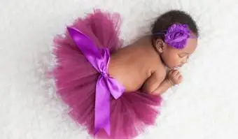 Niña recién nacida con un tutú morado