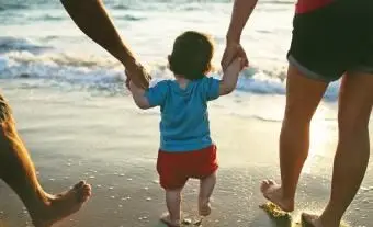 Pai e mãe segurando menino