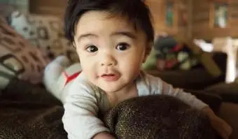 Bambino carino sul divano che fissa la telecamera