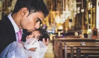 教会の額に女の赤ちゃんにキスする男