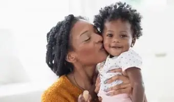 Usmievavá matka sa bozkáva s dieťaťom