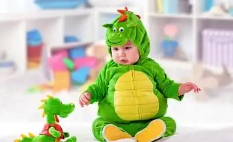 Babyjunge in einem grünen Drachenanzug