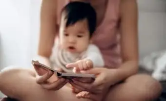 Baby sitzt auf Mutter