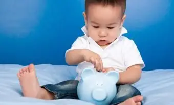 Junge steckt Geld in blaues Sparschwein