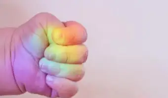 Mano de bebé con colores del arco iris