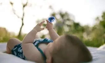 Bebê segurando uma flor