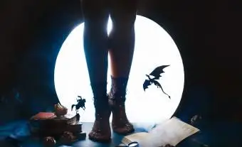 Ragazza con sagome di drago e cavaliere su sfondo luna splendente