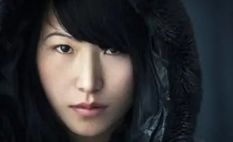 Ragazza asiatica con espressione vuota che indossa una giacca con cappuccio nera