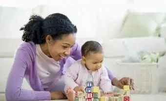 Mujer jugando con bloques con niña