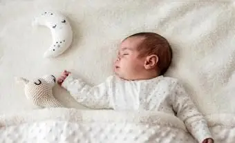 星に手を添えて眠っている赤ちゃん