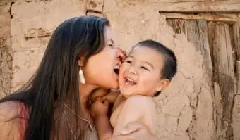 Mère espiègle tenant son fils à l'extérieur