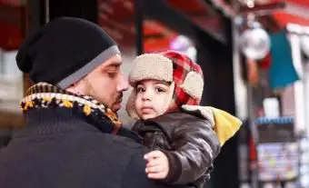 모자와 함께 밖에 서 아빠와 아기