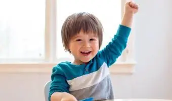 פעוט שמח מרים את ידו