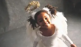 Mädchen, das im Engelskostüm lächelt