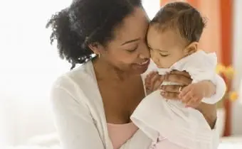 Donna di razza mista che tiene bambino