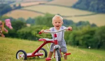 세 발 자전거를 가지고 노는 유아 어린이