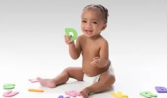 Menina sorridente brincando com brinquedos de letras