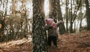 Petite fille debout dans la forêt