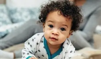 chłopczyk czołgający się na łóżku