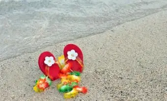 A menina dá uma cambalhota na areia