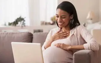 ノートパソコンに座っている妊婦