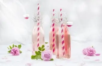 Punch alla rosa in bottiglia con cannucce decorative rosa e bianche