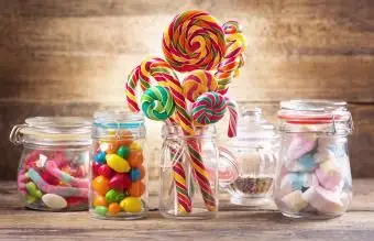 Kolorowe cukierki, galaretki, lizaki, pianki i marmolady w szklanych słoikach