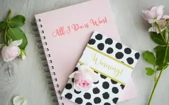 Svieže ružové ruže s dvoma zošitmi