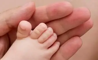 Pie de bebé sostenido por los padres