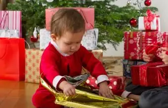 Dziewczynka rozpakowuje prezent świąteczny