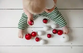 Wysoki kąt widzenia dziecka bawiącego się piłką na podłodze