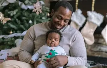 Tata przytula swoją nowonarodzoną córkę w Boże Narodzenie