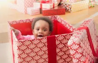 Dziewczynka bawiąca się w świątecznym pudełku prezentowym