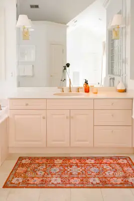 pink vanity with soap, a candle, and a diffuser on it
