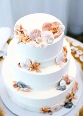 ビーチの装飾が施された白いウエディングケーキ