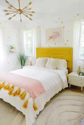 velvet bedframe with throw blanket and star wallpaper on walls