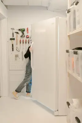 Elsie opening the fridge but we only see her legs from behind the fridge door
