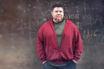 Wielki mężczyzna w graficznym punkowym T-shircie i bluzie z kapturem