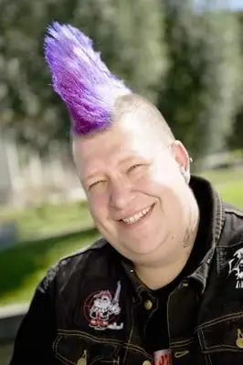 Duży mężczyzna z fioletowym irokezem i punkową kurtką