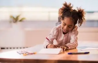 Mała dziewczynka koloruje domową kartkę urodzinową