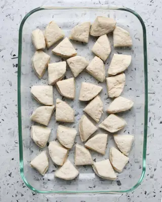 pieces of uncooked biscuits in a glass pan