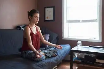 ソファで瞑想する女性