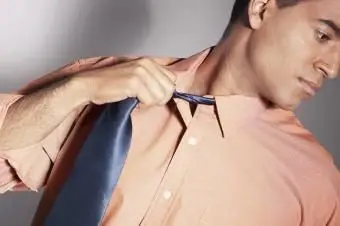 Jeune homme tout habillé s'appuyant sur le mur